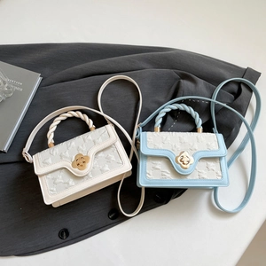 Close-up of embossed texture bags with floral gold buckles and braided top handles