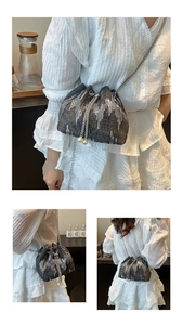 Close-up of sequined bucket bag with drawstring closure and elegant pearl charms