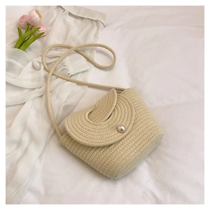 Détail du sac seau tissé avec un fermoir en perle et une bandoulière en corde fine