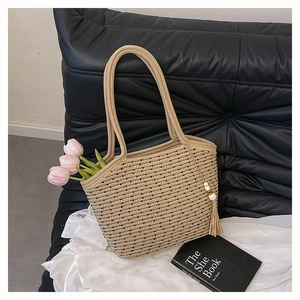 Close-up of woven tote bag texture with tassel charm and pink tulip detail