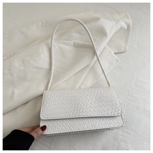 Detailed view of white woven texture and elegant gold hardware on minimalist shoulder bag