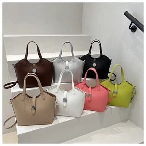 Detail showing various colors of tote bags with N-logo metal locks on white stairs