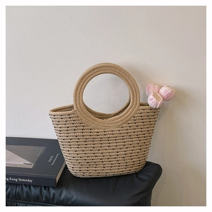 Détail de la texture d'un sac seau tissé beige avec motifs en pointillés et anse anneau