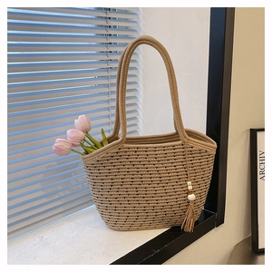 Detailed texture of handwoven tote bag with black stripes and wooden bead tassel
