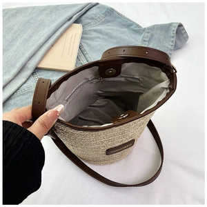 Dettaglio interno borsa a secchiello in paglia con chiusura magnetica e tasca zip