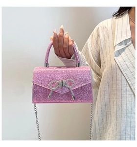 Detail of hot pink sequin evening bag featuring a crystal bow and silver chain strap