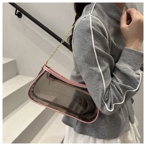 Dettaglio borsa trasparente in PVC con bordo rosa e tracolla a catena dorata
