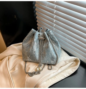 Close-up of denim bucket bag with silver sequins and pearl drawstring details