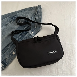 Vue détaillée du sac à bandoulière en nylon noir avec une étiquette Fashion blanche