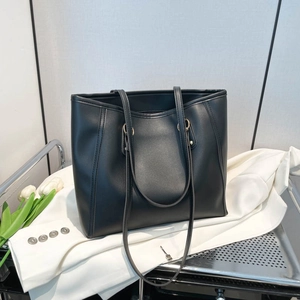 Minimalist black faux leather tote bag with gold ring buckle and long shoulder straps