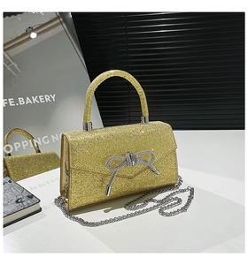 Detailed macro view of yellow sequin evening bag with crystal bow and silver chain