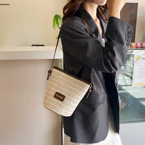 Borsa a secchiello in paglia da donna con finiture in pelle marrone e tracolla incrociata