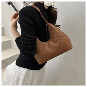 Detailed view of brown woven texture and crescent shape on a stylish hobo shoulder bag