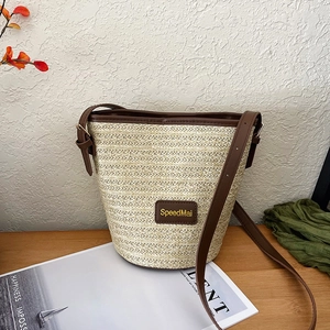Borsa a secchiello in paglia estiva con finiture in pelle marrone e tracolla su legno