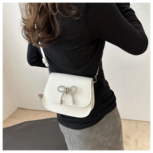 White leather saddle bag with silver butterfly detail shown on a female model