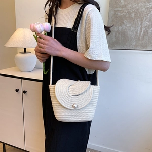 Sac seau tissé blanc avec fermoir perle et détail de rabat circulaire porté par modèle