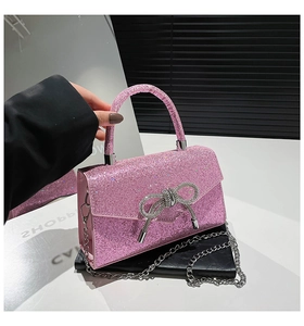 Detail of pink sequin evening bag featuring a silver rhinestone bow clasp and chain