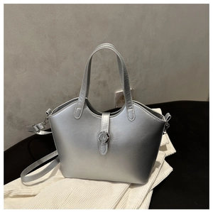 Detail of metallic silver tote bag featuring high-shine finish and round magnetic clasp