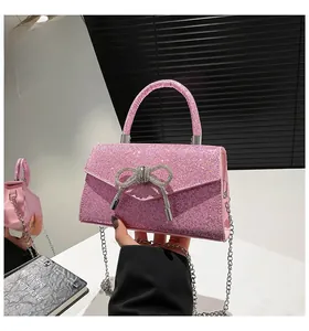Detailed view of pink sequin evening bag with sparkling rhinestone bow and chain strap