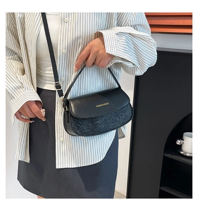 Detail of black sequined crossbody bag with golden Fashion & Bags text on leather flap