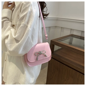 Detail of pink PU leather flap bag featuring a sparkling silver rhinestone butterfly