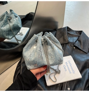 Detail of light blue denim bucket bag with silver sequins and pearl drawstring