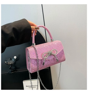Close-up of pink sequin party handbag featuring a crystal bow and silver metal handle
