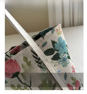 Detail shot of vintage floral jacquard tote bag with premium white leather handle stitching