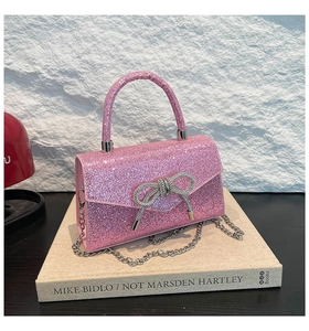 Detail of pink sequin party bag featuring a sparkling crystal bow and silver chain strap