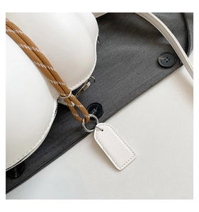 Detail of white leather wavy bag featuring woven rope accent and minimalist zipper closure