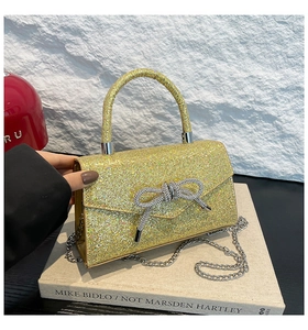 Macro shot of gold sequin evening bag with a sparkling rhinestone bow buckle detail