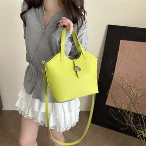 Lime green minimalist leather handbag with silver buckle shown by a model on shoulder
