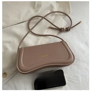 Size comparison of the stylish curved handbag next to a smartphone on velvet cloth