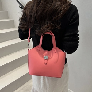 Pink vintage leather tote bag shown on shoulder with silver round buckle and sleek finish