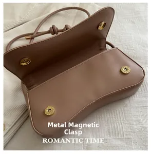 Detail of the dual golden magnetic hardware buckles on a retro hobo shoulder bag