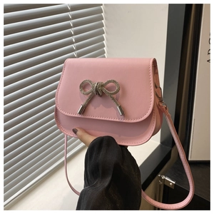 Close-up of pink leather crossbody bag with sparkling rhinestone butterfly decoration