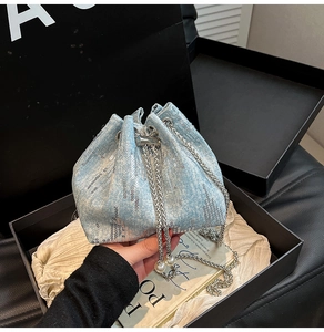 Detail of light blue denim bucket bag with silver sequins and pearl drawstring decor