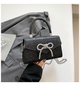 Macro detail of black sequined evening bag featuring a silver rhinestone bow buckle