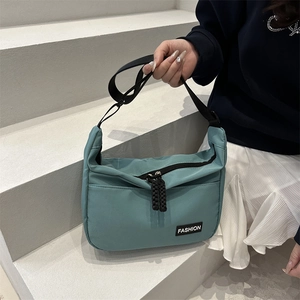 Sac bandoulière en nylon cyan avec sangle réglable et détail d'étiquette de mode