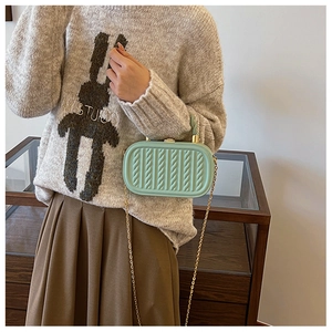Detail of mint green box bag featuring twisted cable texture and gold metal kiss-lock
