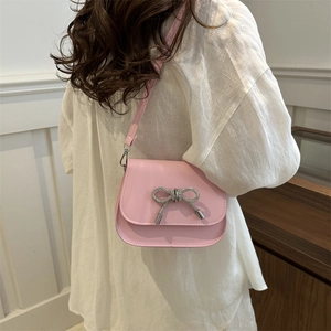 Pink crossbody bag with silver rhinestone butterfly on flap, minimalist fashion style