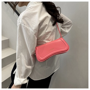 Pink faux leather shoulder bag worn over the shoulder with a clean white shirt background