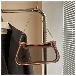 Dettaglio della borsa in PVC trasparente con bordi in pelle rosa e tracolla a catena d'oro