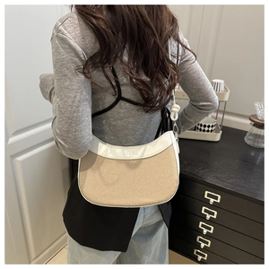 Détail d'un sac seau minimaliste en cuir contrasté avec textures tissées pour femmes