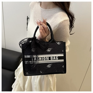 Detail of floral jacquard tote bag with fashion text and oversized lace bow accessory