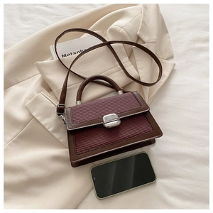 Vue de dessus d'un sac bandoulière tissé bordeaux avec un smartphone pour comparer la taille