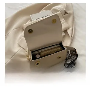 Interior view showing large capacity of the beige woven crossbody bag with wide strap