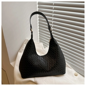 Detailed view of black woven faux leather texture on a stylish half-moon hobo bag