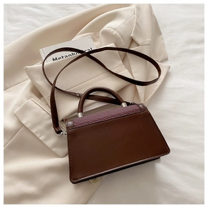 Détail du sac à main bicolore montrant le cuir marron et le rabat à texture tissée violette