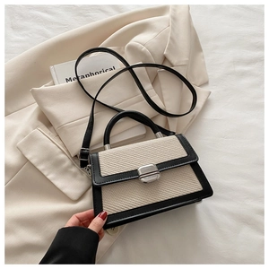 Détails du sac à main texturé contrasté avec boucle argentée et bandoulière noire